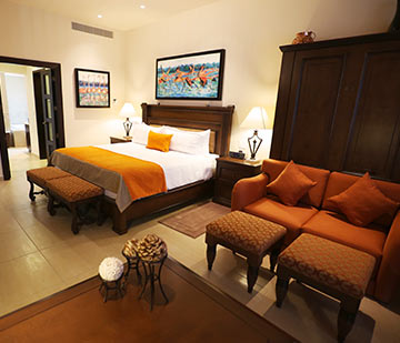 Suite en resort frente al mar con amplio dormitorio con una cama king size y una cama individual plegable